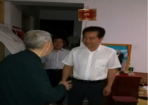 图为李刚副市长与退休老党员亲切握手
