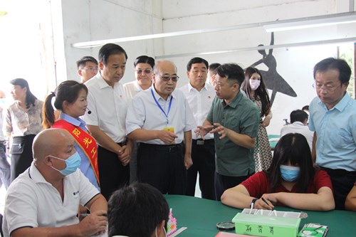图为郑州市人大常委会在富士康阳光工场了解残疾人就业培训工作