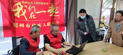 图为郑州市残联工作人员为残疾人办理绿城通关爱卡年审新办工作