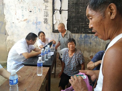图为评定小组在水坡镇朱岗村为残疾人办理残疾证