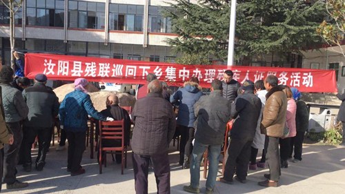 图为：汝阳县残联巡回下乡集中办理残疾人证服务活动