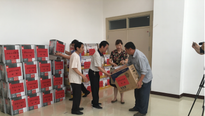 图为：市残联理事长杨广欣为残疾人发放捐赠物资
