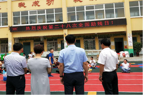 图为：孟津县政府领导到培智学校慰问残疾儿童
