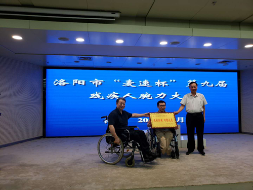 图为：刘峥伟理事和张国美副理事长为麦速网络科技有限公司颁发“扶残助残”牌匾。