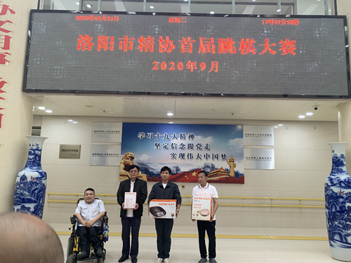 图为：洛阳市精神残疾人及亲友协会主席蒋庆伟为获奖运动员颁奖
