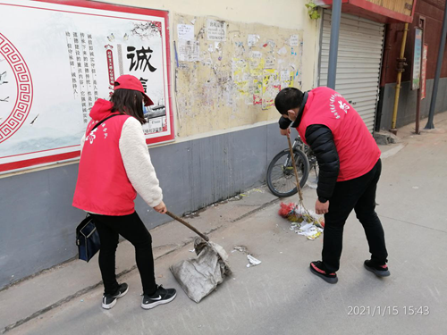 图为：市残联志愿者在清扫地面垃圾