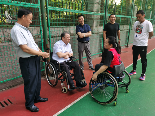 图为：省肢协主席刘峥伟在集训赛场了解新运动员集训情况