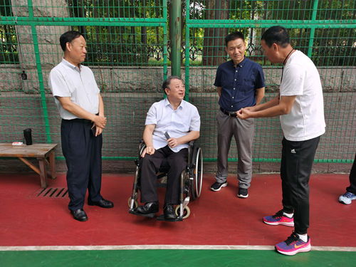 图为：省肢协主席刘峥伟和教练员交流集训情况