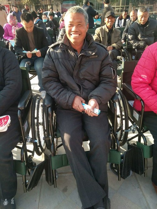 图为贫困残疾人家属参加轮椅捐赠仪式