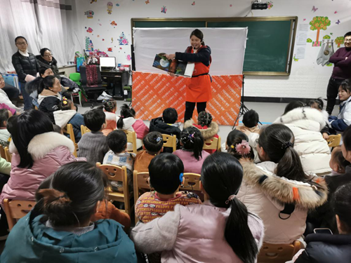 图为燕子老师和听障儿童一起阅读立体绘本《好饿的毛毛虫》