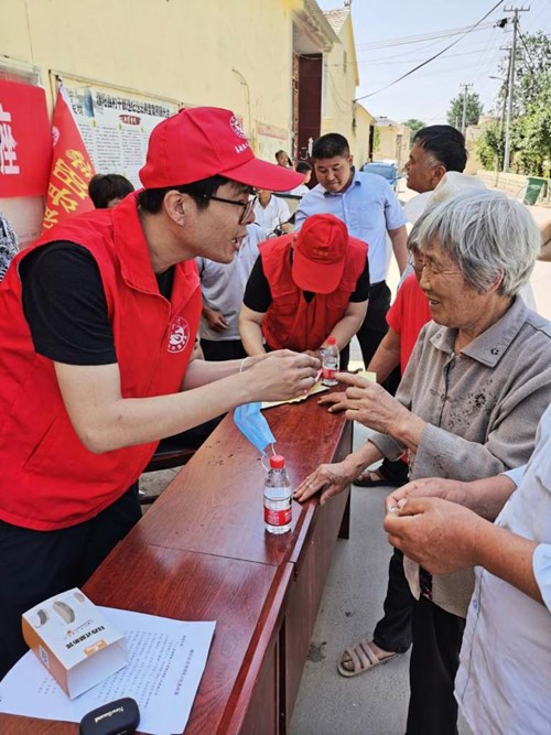 图为：残联康复部负责同志现场指导残疾人辅具的维护与使用