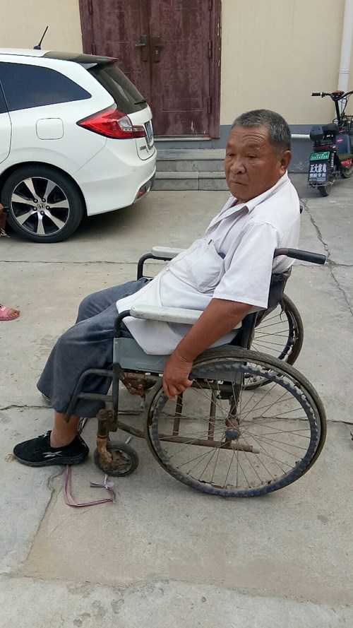 图为残疾人维持使用的破旧轮椅
