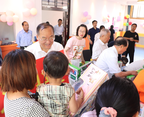 图为濮阳市政府副市长黄守玺为听障儿童送上儿童节礼物