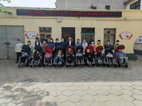 图为：南乐县残联发放儿童轮椅现场