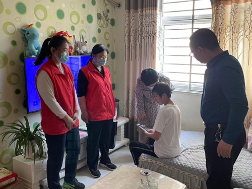 图为：图为：市残联张湘鄂副理事长与残疾朋友亲密交谈