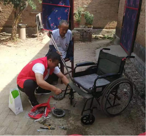 图为工作人员正在维修轮椅