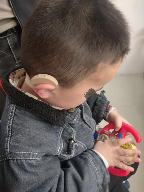 图为残疾儿童佩戴助听器