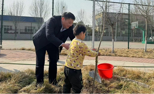 图为市残联党组书记、理事长李湘与孩子们一起栽树