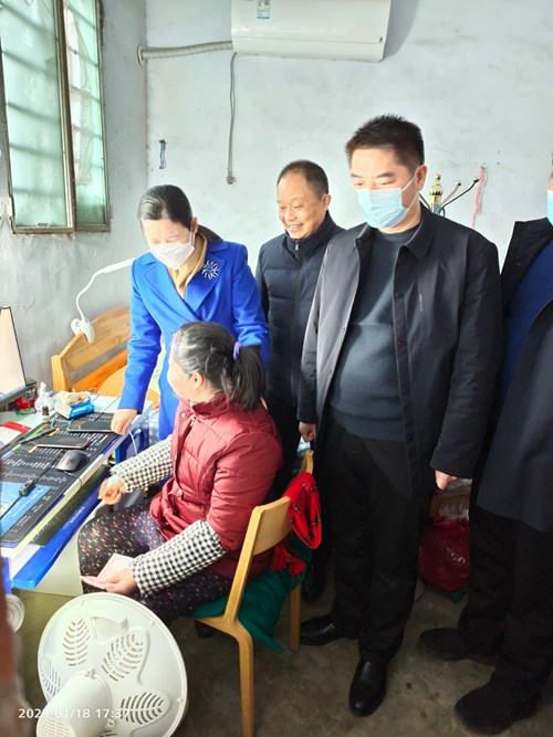 图为县长余国芳等一行在残疾人刘泽霞家庭慰问，并了解节前电商经营情况