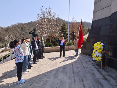 图为罗山县残联党组书记、理事长胡汉成带领党员们在纪念碑前重温入党誓词