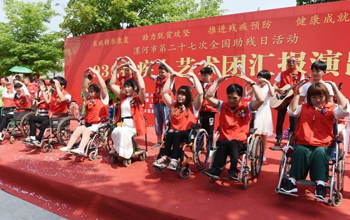 图为残疾人艺术团成员与学生志愿者一起表演手语舞蹈《感恩的心》