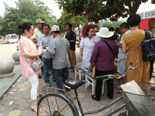 图为县残联、县中医院工作人员在金龙广场开展残疾预防宣传活动