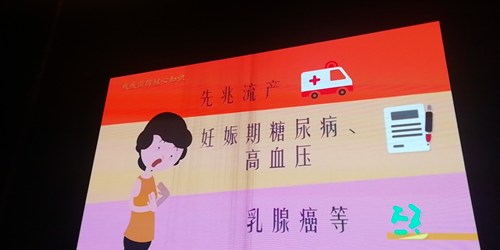 图为广场大屏幕播放残疾预防公益宣传片孕前检查内容