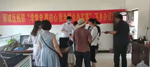 图为区残联在商桥镇为残疾人进行下乡办证服务