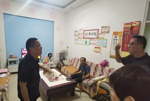 图为郾城区残联副理事长李琦磊询问残疾人家庭情况和困难需求