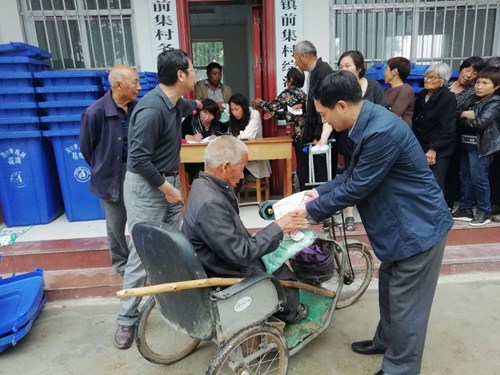 图为市残联党组书记、李德峰为残疾人贫困户捐赠衣物
