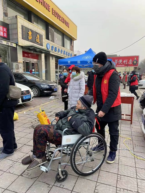 图为文峰区残联志愿者帮助残疾人接受检测